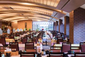 热海汤河原纽威尔西提日式旅馆的大型用餐室配有桌椅