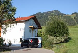 博尔斯特尔朗Ferienwohnung Gipfelstürmer的停在白色房子前面的一辆黑色货车