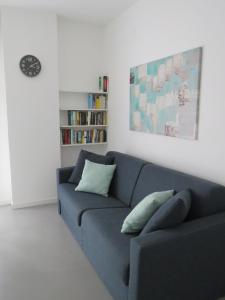 阿萨哥Assago Forum Apartment的客厅设有蓝色的沙发和书架