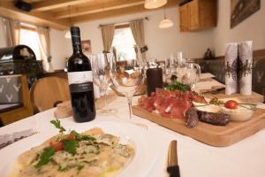 阿尔卑斯休斯山Mahlknechthuette Seiseralm的一张桌子,上面放着一瓶葡萄酒和一盘肉类