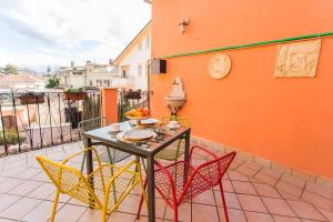 阿韦扎诺Garibaldi33的阳台配有桌椅和橙色墙壁
