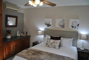 彼得马里茨堡Hamilton Urban Farm Guest House的一间卧室配有一张床和吊扇