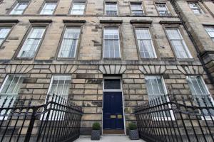爱丁堡Escape To Edinburgh @ Albyn Place的一座石头建筑,设有蓝色的门和窗户