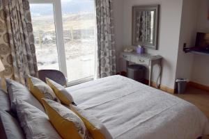 塔伯特Dunarain Bed & Breakfast的一间卧室设有一张床和一个大窗户