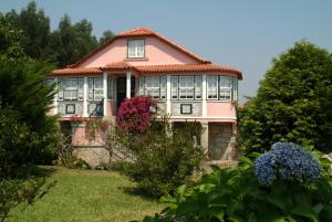 维亚纳堡Quinta do Vale do Monte的院子里的粉红色房子,带窗户和鲜花