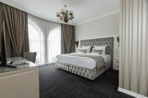 克拉斯诺达尔Boutique-hotel Stolica的一间卧室配有一张大床和一个吊灯。