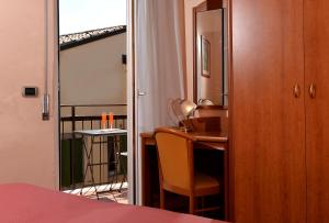 维罗纳西耶那酒店的一间卧室配有书桌、椅子和镜子