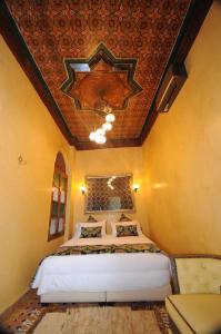 梅克内斯Riad Mama H&K的一间带一张床铺的卧室,位于带天花板的房间内