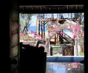 吉利特拉旺安日落海滩别墅酒店的享有花园粉红色花卉美景的窗户