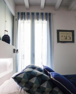 卡斯泰拉马莱Calida B&B的一间卧室设有窗户,配有蓝色窗帘和一张床