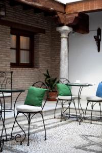 格拉纳达卡萨奎斯塔德尔瓜公寓酒店的庭院里摆放着带绿色枕头的椅子