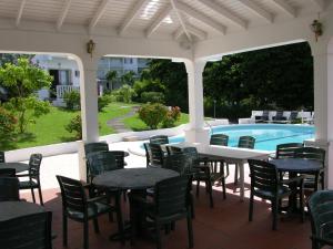 Morne Rouge塞尔斯塔酒店的一个带桌椅的庭院和一个游泳池