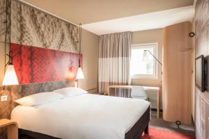 戈内斯ibis Gonesse的酒店客房,设有白色的床和红色的墙壁