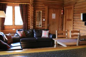 伊文格瑞Highgarry Lodges的客厅配有真皮沙发和桌子