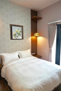 竹山山林别苑的卧室设有一张白色大床和一扇窗户。