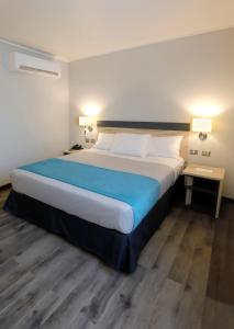 维纳德马Hotel Diego de Almagro Viña del Mar的一张大床,位于酒店房间,设有两张桌子