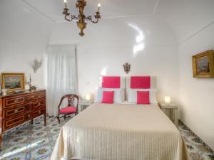 卡普里西尔维亚公寓的卧室配有一张带粉红色枕头的大床