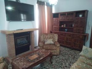 蒙特弗里奥Casa de Los Albas 4p的客厅设有壁炉、椅子和电视