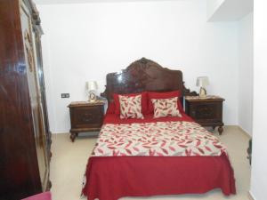 蒙特弗里奥Casa de Los Albas 4p的一间卧室配有红色枕头和一张红色大床