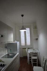佛罗伦萨Casa Naldi 2的厨房配有桌子和白色冰箱。