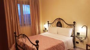 BonoLe Tre Rose的一间卧室配有一张带白色床单的床和一扇窗户。