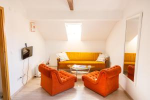 武科瓦尔Apartmani Maraton的客厅配有两把橙色椅子和一张沙发