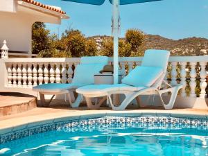 法鲁Luxury Casa da Fonte - Private Heated Pool的游泳池旁的一对蓝色椅子
