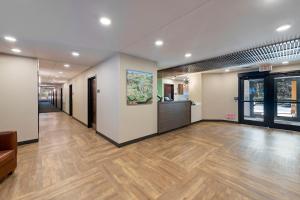 夏洛特美洲长期住宿酒店 - 夏洛特 - 派恩维尔 - 公园路的办公室的走廊,铺有木地板