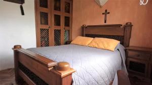 雷蒂罗Apartamento Acogedor en el Retiro的卧室配有木床,墙上有十字架