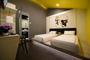 新加坡Venue Hotel的一间卧室设有两张床和一个鲜花柜台。