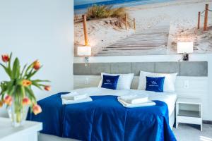 尤斯托尼莫斯基White Marina Apartamenty的一间卧室配有一张带蓝色床单的床和楼梯。