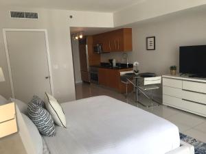 迈阿密Icon Residences by SS Vacation Rentals的一间带白色床的卧室和一间厨房