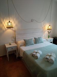休达德亚Hostal Sa Posada Set Cales的一间卧室配有一张大床和毛巾