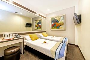 新加坡Hotel 81 Bugis的酒店客房配有两张床和一张书桌