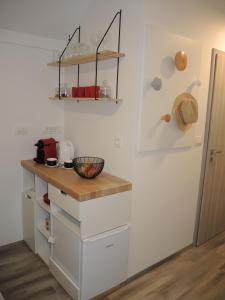 卡姆尼克Mamut Stay的厨房配有白色橱柜和木台面