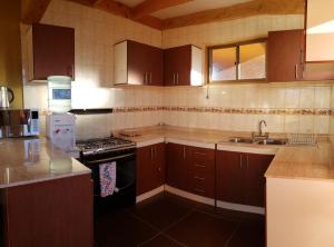 圣佩德罗·德·阿塔卡马Hostal Pablito 2的厨房配有水槽和炉灶 顶部烤箱