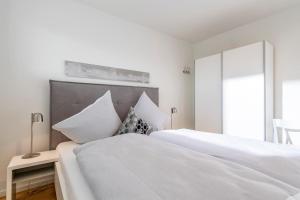 奥尔本尼兹Harbour Side的卧室设有2张床和白色的墙壁。
