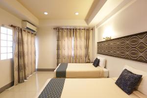 宋卡V公寓式酒店 的一间卧室设有两张床和窗户。