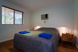 埃克斯茅斯珀索特度假酒店的一间卧室配有一张带蓝色枕头的床。