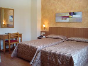 阿尔巴塞特卡斯蒂利亚酒店的酒店客房设有两张床和一张桌子。