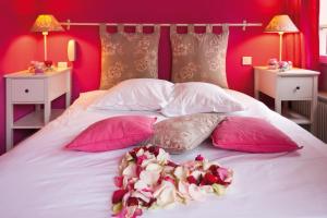 斯特拉斯堡Le Kléber Hôtel的一张带粉色和白色枕头的床,床上有鲜花