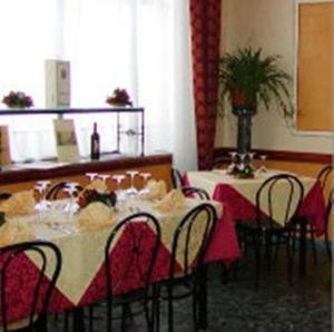 蒙蒂菲阿斯科尼阿尔塔维拉酒店的用餐室配有桌椅和桌椅
