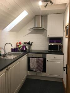 爱丁堡Drum Brae Cottage的厨房配有水槽和炉灶 顶部烤箱