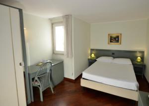 巴里左狄雅库斯公寓的一间卧室配有一张床、一张书桌和一个窗户。