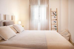 滨海波利尼亚诺TorreParadiso Holidays的卧室设有一张白色大床和一扇窗户。