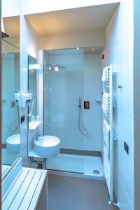 阿西西梦德诺酒店的一间带玻璃淋浴和水槽的浴室