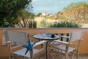 VolissosPorto Limnia的美景阳台配有一张桌子和两把椅子