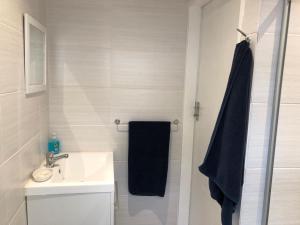 约翰内斯堡Forest Haven的浴室设有水槽和带黑色毛巾的淋浴。