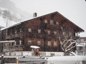 东蒂罗尔地区马特赖Ferienhaus Innerkienzerhof - Urlaub am Bauernhof的一座大木结构建筑,有雪