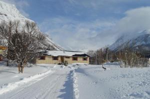 OlderdalenLyngenfjord, Frøyas hus的一条有雪覆盖的道路,后面有一座房子